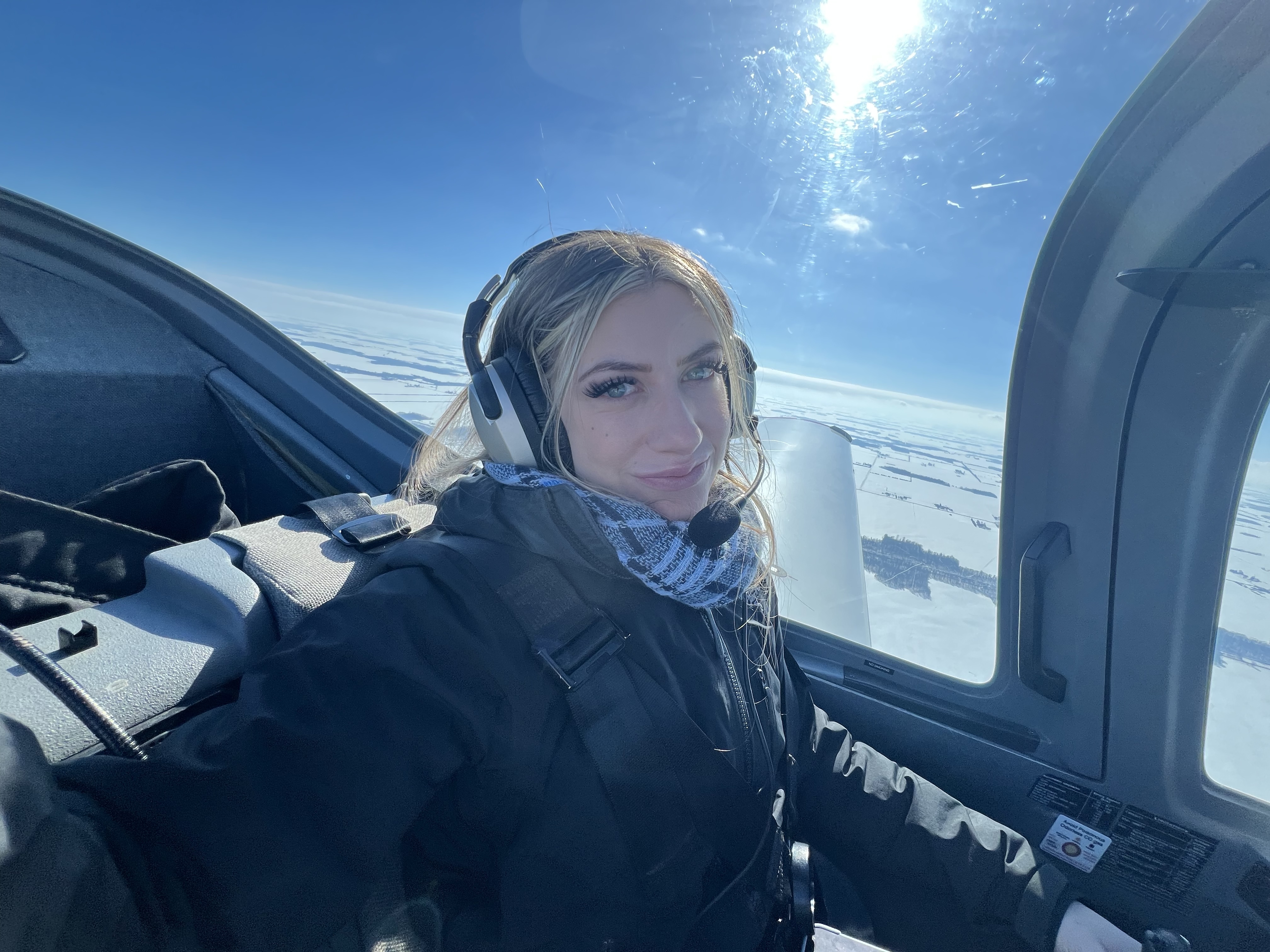 Vanessa Waugh in the cockpit above a snow-covered winter landscape
